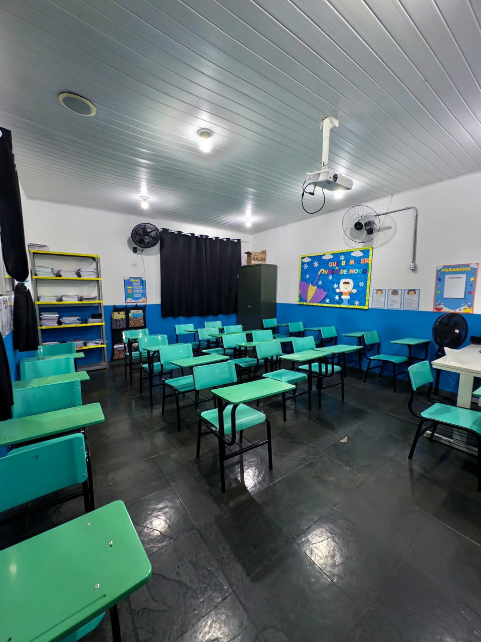 Sala de aula com carteiras verdes e decoração lúdica